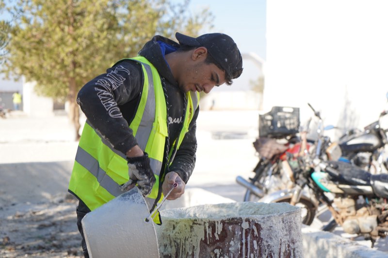 A young worker mixing plaster