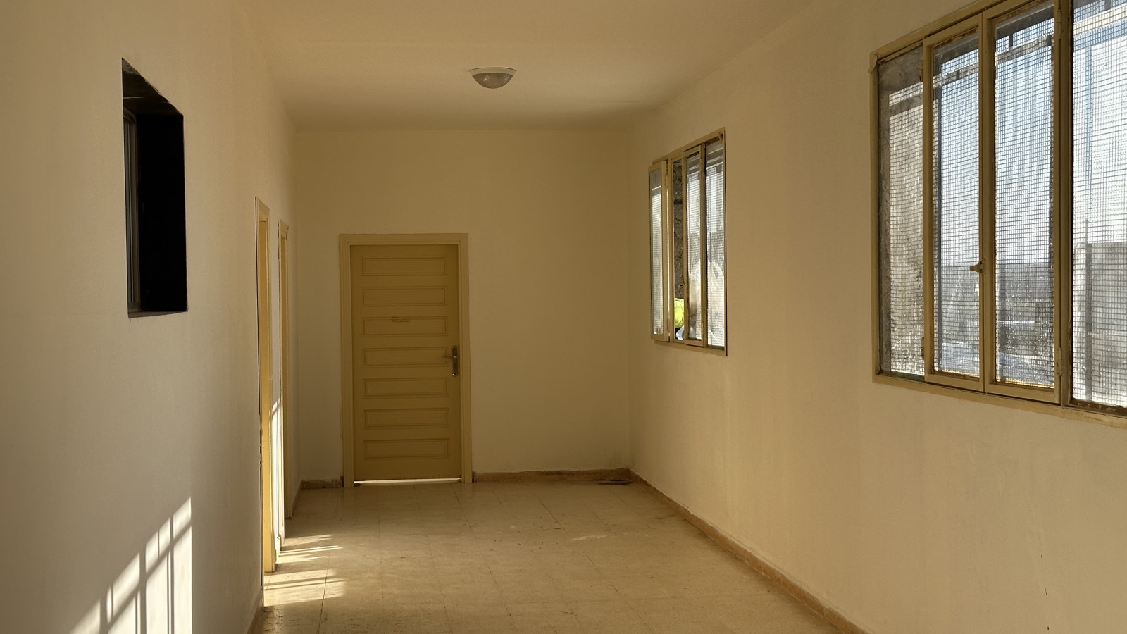 A freshly restored, sunlit school corridor rebuilt by Uncle T